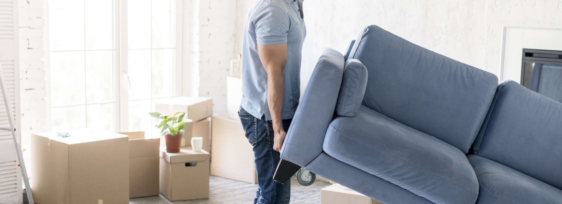 homme-souleve-canape-en-demenagement Homme soulève un canapé lors d'un déménagement